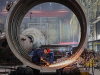 An employee works on a large pressure vessel customized by an oil refinery at the production workshop of Qingdao Lanshi Heavy Machinery Equi...