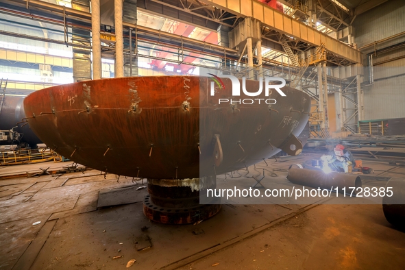 An employee works on a large pressure vessel customized by an oil refinery at the production workshop of Qingdao Lanshi Heavy Machinery Equi...