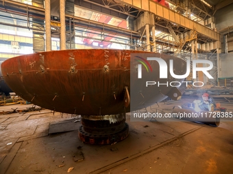 An employee works on a large pressure vessel customized by an oil refinery at the production workshop of Qingdao Lanshi Heavy Machinery Equi...