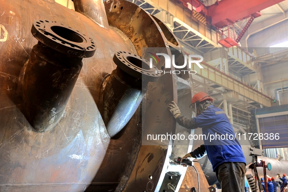 An employee works on a large pressure vessel customized by an oil refinery at the production workshop of Qingdao Lanshi Heavy Machinery Equi...