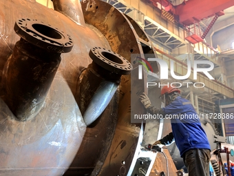 An employee works on a large pressure vessel customized by an oil refinery at the production workshop of Qingdao Lanshi Heavy Machinery Equi...