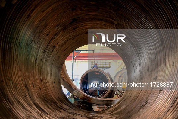 An employee works on a large pressure vessel customized by an oil refinery at the production workshop of Qingdao Lanshi Heavy Machinery Equi...