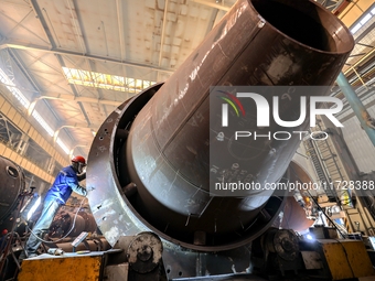 An employee works on a large pressure vessel customized by an oil refinery at the production workshop of Qingdao Lanshi Heavy Machinery Equi...