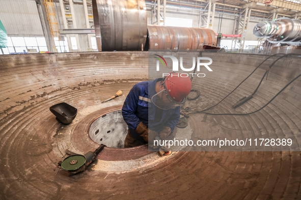 An employee works on a large pressure vessel customized by an oil refinery at the production workshop of Qingdao Lanshi Heavy Machinery Equi...