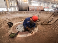 An employee works on a large pressure vessel customized by an oil refinery at the production workshop of Qingdao Lanshi Heavy Machinery Equi...