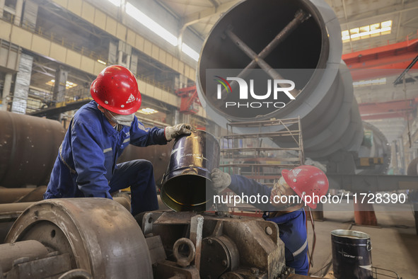 An employee works on a large pressure vessel customized by an oil refinery at the production workshop of Qingdao Lanshi Heavy Machinery Equi...