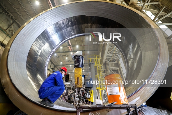 An employee works on a large pressure vessel customized by an oil refinery at the production workshop of Qingdao Lanshi Heavy Machinery Equi...