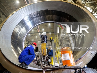 An employee works on a large pressure vessel customized by an oil refinery at the production workshop of Qingdao Lanshi Heavy Machinery Equi...