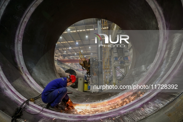 An employee works on a large pressure vessel customized by an oil refinery at the production workshop of Qingdao Lanshi Heavy Machinery Equi...