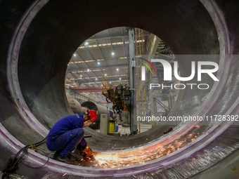 An employee works on a large pressure vessel customized by an oil refinery at the production workshop of Qingdao Lanshi Heavy Machinery Equi...