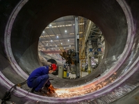 An employee works on a large pressure vessel customized by an oil refinery at the production workshop of Qingdao Lanshi Heavy Machinery Equi...