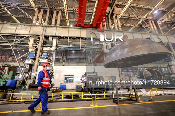 An employee works on a large pressure vessel customized by an oil refinery at the production workshop of Qingdao Lanshi Heavy Machinery Equi...