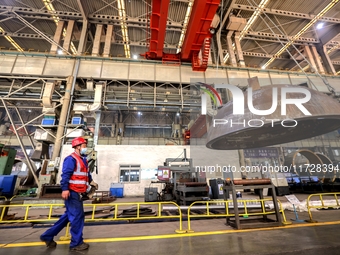 An employee works on a large pressure vessel customized by an oil refinery at the production workshop of Qingdao Lanshi Heavy Machinery Equi...