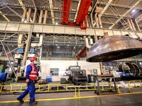 An employee works on a large pressure vessel customized by an oil refinery at the production workshop of Qingdao Lanshi Heavy Machinery Equi...