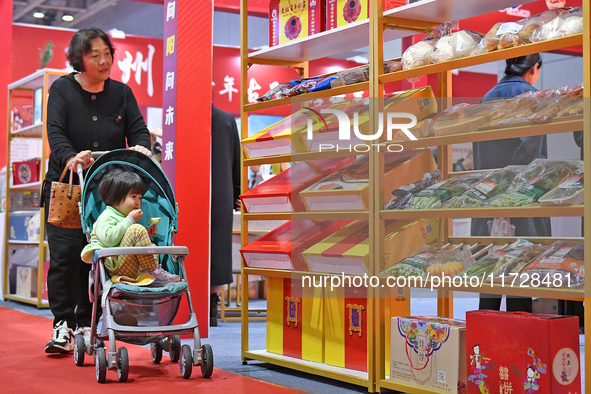 A visitor brings a child to the 2024 Yantai International Food (Prepared Dishes) Industry Expo in Yantai, China, on November 1, 2024. 