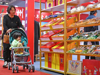 A visitor brings a child to the 2024 Yantai International Food (Prepared Dishes) Industry Expo in Yantai, China, on November 1, 2024. (