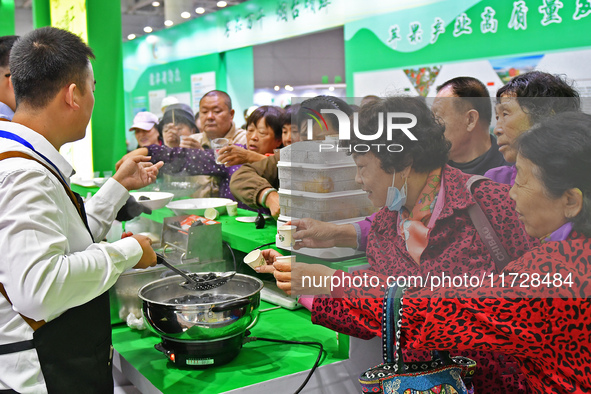 Visitors taste juice drinks at the 2024 Yantai International Food (Prepared Dish) Industry Expo in Yantai, China, on November 1, 2024. 