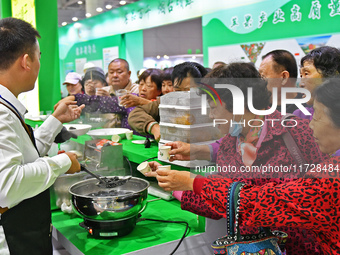 Visitors taste juice drinks at the 2024 Yantai International Food (Prepared Dish) Industry Expo in Yantai, China, on November 1, 2024. (