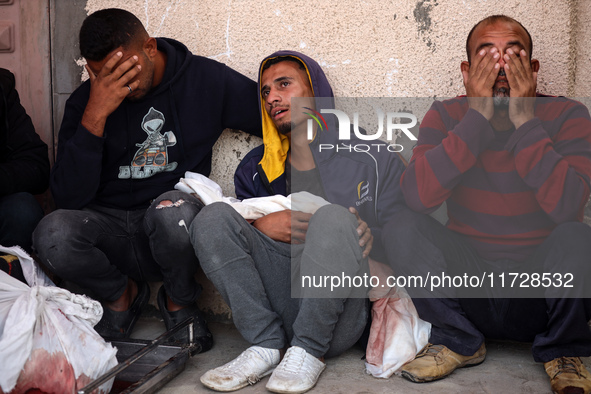 Palestinians surround the body of a victim from an Israeli airstrike that targets a house in the Nuseirat refugee camp in central Gaza, at t...