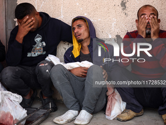 Palestinians surround the body of a victim from an Israeli airstrike that targets a house in the Nuseirat refugee camp in central Gaza, at t...