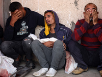 Palestinians surround the body of a victim from an Israeli airstrike that targets a house in the Nuseirat refugee camp in central Gaza, at t...