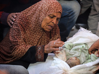 (EDITOR'S NOTE: Image depicts death) A Palestinian woman mourns her grandson, one of the victims of an Israeli bombing that targets a house...