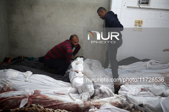 (EDITOR'S NOTE: Image depicts death) A Palestinian stands beside the bodies of victims from an Israeli airstrike that targets a house in the...