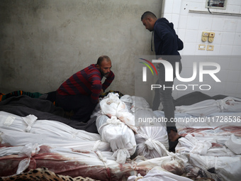 (EDITOR'S NOTE: Image depicts death) A Palestinian stands beside the bodies of victims from an Israeli airstrike that targets a house in the...