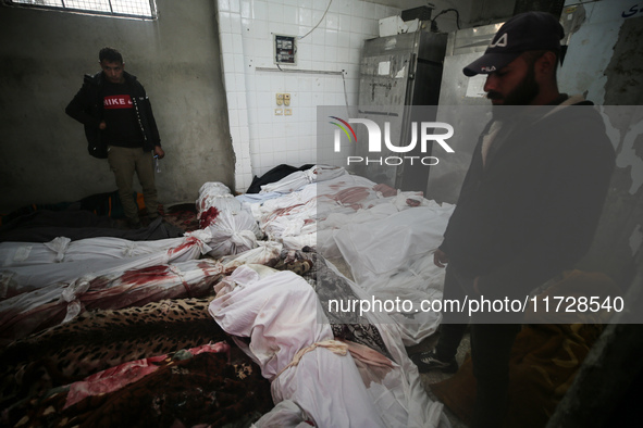 (EDITOR'S NOTE: Image depicts death) Two Palestinians stand beside the bodies of victims from an Israeli airstrike that targets a house in t...