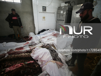 (EDITOR'S NOTE: Image depicts death) Two Palestinians stand beside the bodies of victims from an Israeli airstrike that targets a house in t...