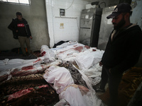 (EDITOR'S NOTE: Image depicts death) Two Palestinians stand beside the bodies of victims from an Israeli airstrike that targets a house in t...