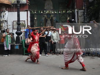 Girls wield bamboo sticks during an event to demonstrate self-defense skills as part of the celebration of the Hindu festival of Kali Puja o...