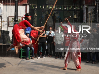 Girls wield bamboo sticks during an event to demonstrate self-defense skills as part of the celebration of the Hindu festival of Kali Puja o...