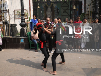 Girls wield knives during an event to demonstrate self-defense skills as part of the celebration of the Hindu festival of Kali Puja outside...