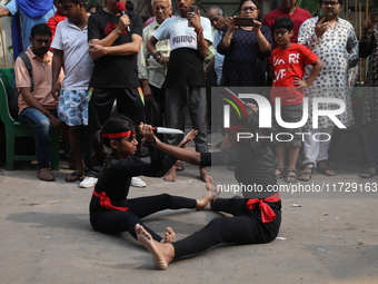 Girls wield knives during an event to demonstrate self-defense skills as part of the celebration of the Hindu festival of Kali Puja outside...