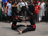 Girls wield knives during an event to demonstrate self-defense skills as part of the celebration of the Hindu festival of Kali Puja outside...