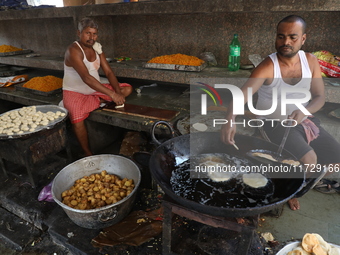 Workers prepare offerings before distributing them to devotees after worship as part of the celebration of the Hindu festival of Kali Puja o...