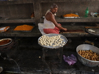 A worker prepares offerings before distributing them to devotees after worship as part of the celebration of the Hindu festival of Kali Puja...