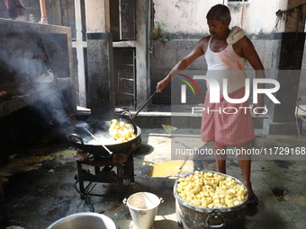 A worker prepares offerings before distributing them to devotees after worship as part of the celebration of the Hindu festival of Kali Puja...