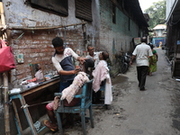 People get a shave from roadside barbers before they attend the Hindu festival of Kali Puja outside a ''pandal'' (a permanent platform), a d...