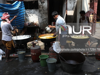 Workers prepare offerings before distributing them to devotees after worship as part of the celebration of the Hindu festival of Kali Puja o...