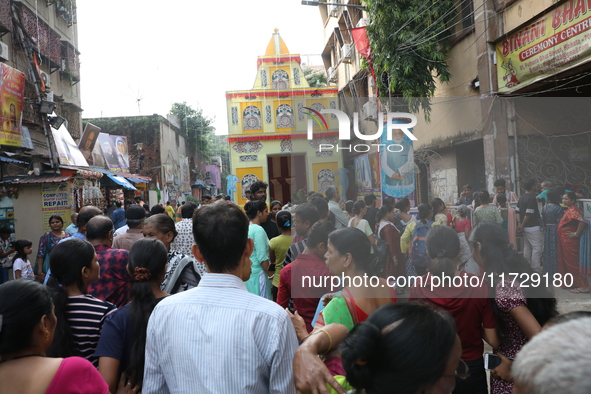 Devotees stand in a queue to have offerings after worshiping the Hindu goddess Kali outside a ''pandal'' (a temporary platform), a decorated...