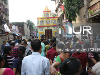 Devotees stand in a queue to have offerings after worshiping the Hindu goddess Kali outside a ''pandal'' (a temporary platform), a decorated...