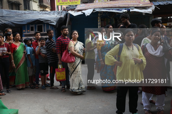 Devotees stand in a queue to have offerings after worshiping the Hindu goddess Kali outside a ''pandal'' (a temporary platform), a decorated...