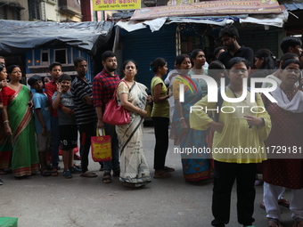 Devotees stand in a queue to have offerings after worshiping the Hindu goddess Kali outside a ''pandal'' (a temporary platform), a decorated...