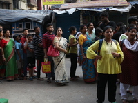 Devotees stand in a queue to have offerings after worshiping the Hindu goddess Kali outside a ''pandal'' (a temporary platform), a decorated...