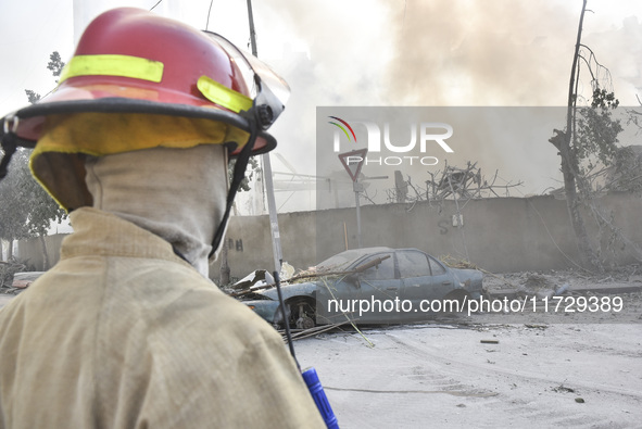 Firefighters extinguish the blaze at the site of overnight Israeli airstrikes that target the neighborhood of Kafaat in Beirut's southern su...