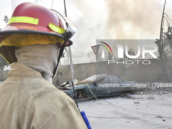 Firefighters extinguish the blaze at the site of overnight Israeli airstrikes that target the neighborhood of Kafaat in Beirut's southern su...