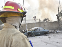 Firefighters extinguish the blaze at the site of overnight Israeli airstrikes that target the neighborhood of Kafaat in Beirut's southern su...