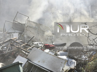 Firefighters extinguish the blaze at the site of overnight Israeli airstrikes that target the neighborhood of Kafaat in Beirut's southern su...